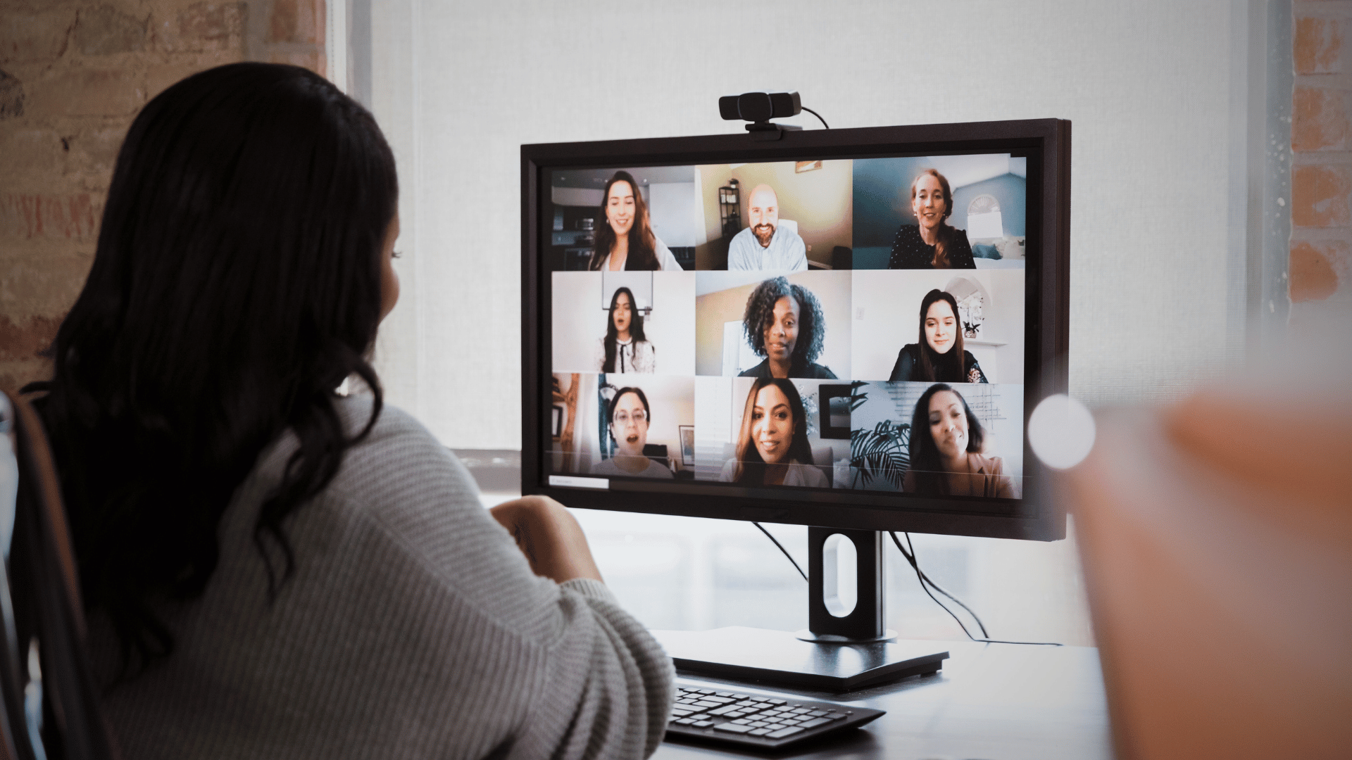 woman on video conference with remote team members