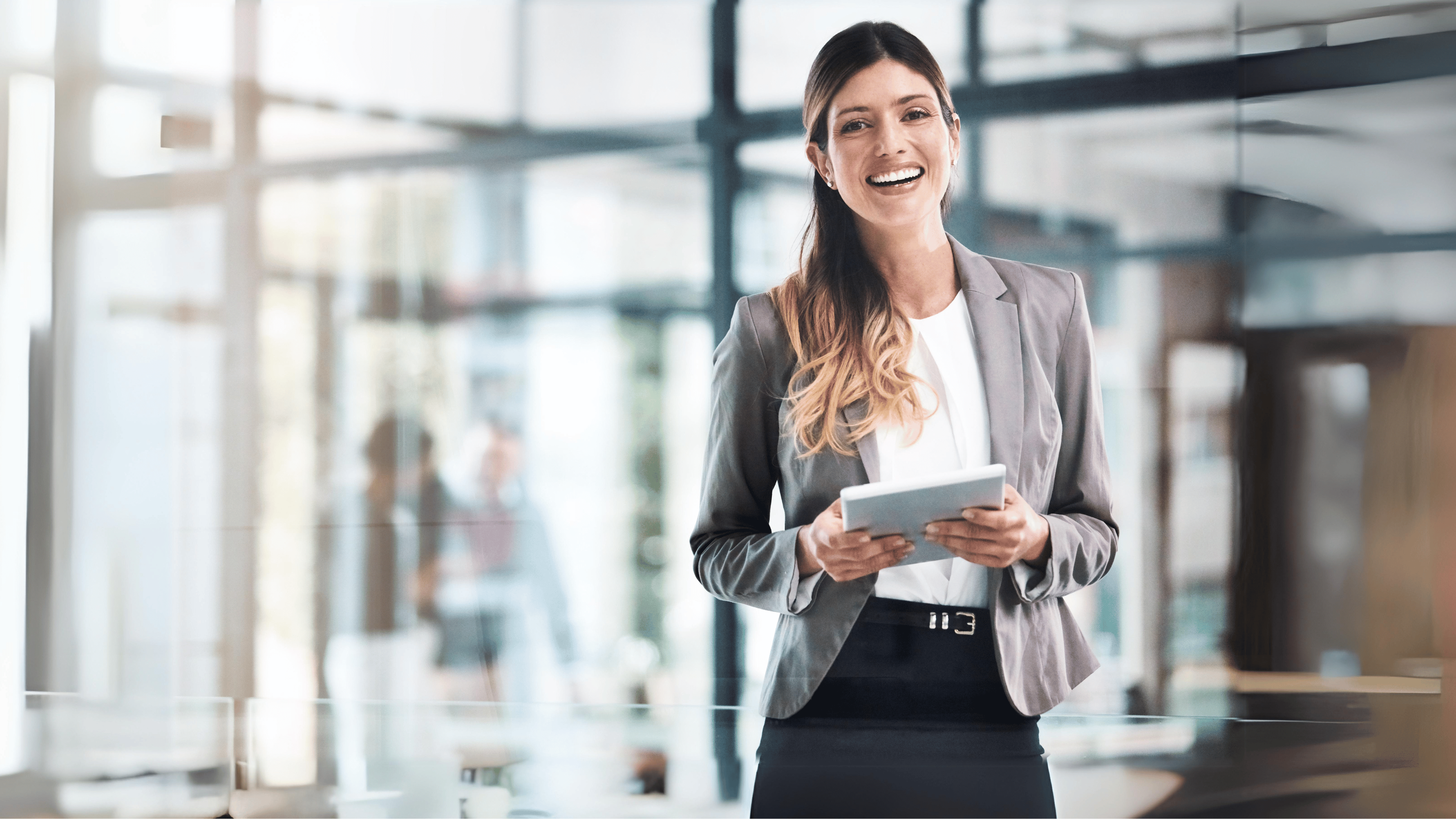 Portrait of a young woman holding a tablet at a modern office space