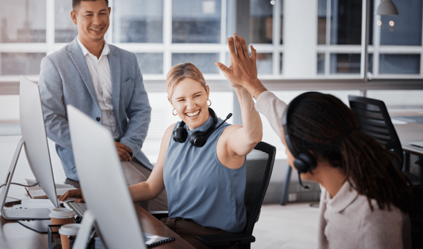 happy colleagues high-fiving each other at the office