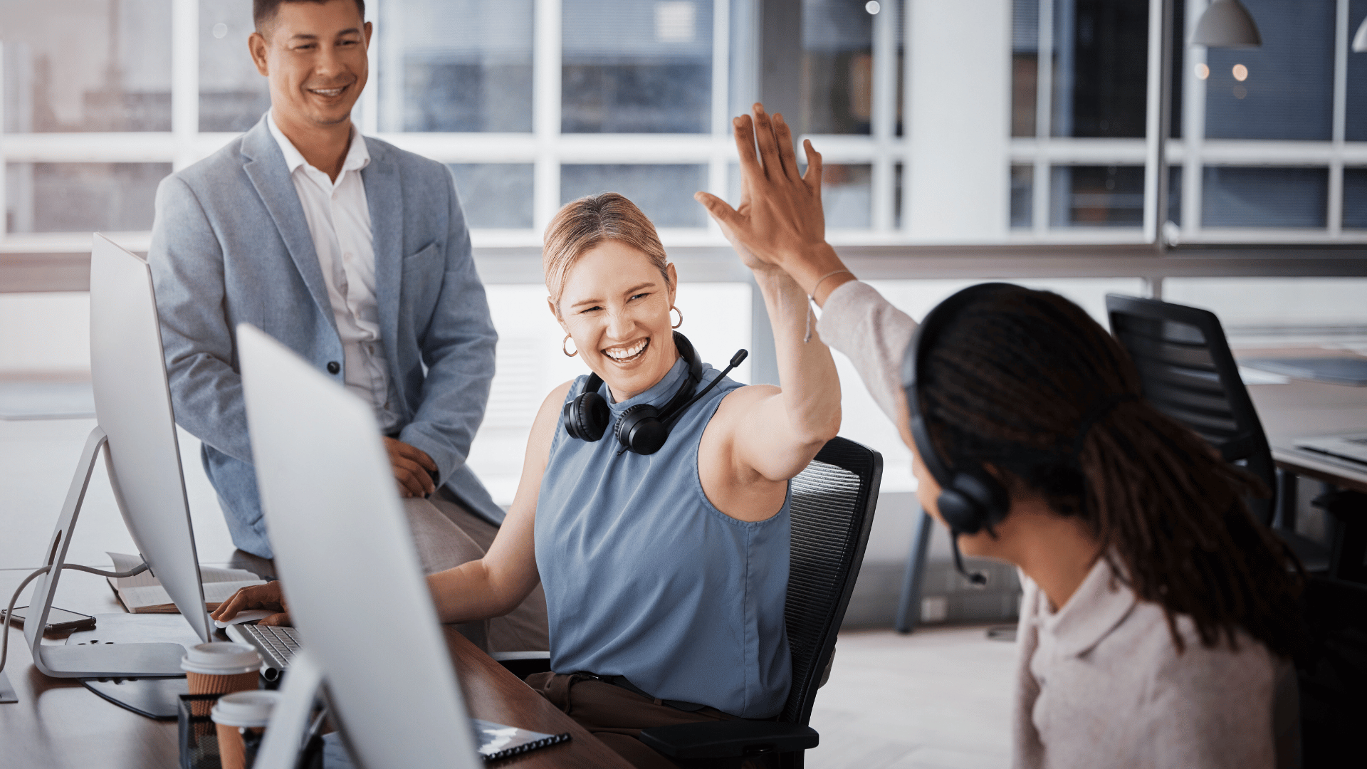 happy colleagues high-fiving each other at the office