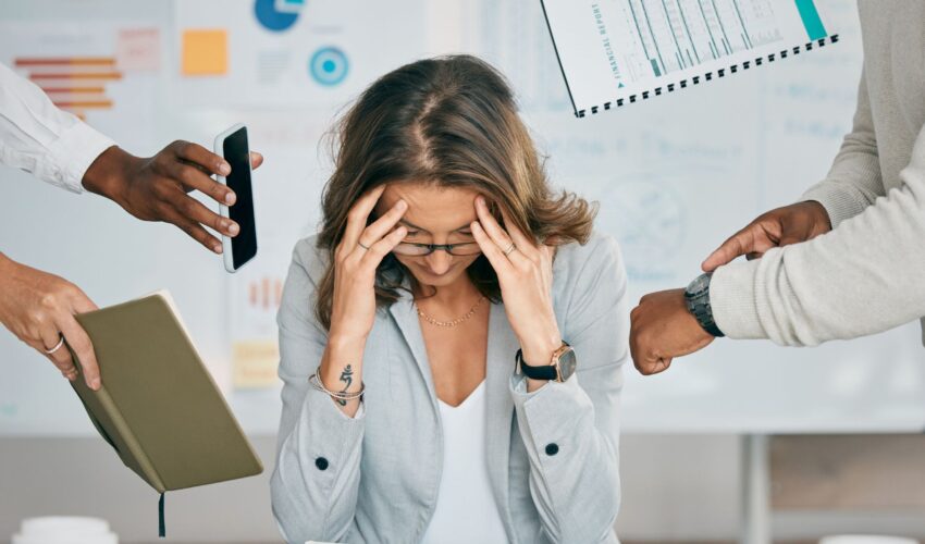 WorkFromPH.com blog photo of an overwhelmed woman business owner, multitasking female in office with demands from everyone